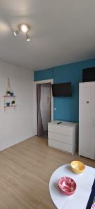 a living room with a white refrigerator and a table at Charmant Studio Cosy Confort in Alfortville