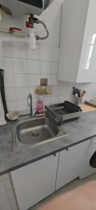 a kitchen counter with a stainless steel sink at Charmant Studio Cosy Confort in Alfortville