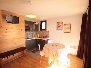 eine Küche und ein Esszimmer mit Tisch und Stühlen in der Unterkunft Charmant appart au 2e étage, 5 pers, balcon, WiFi, casier à skis, Les Saisies - FR-1-293-287 in Hauteluce