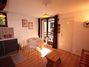 eine Küche und ein Esszimmer mit Tisch und Stühlen in der Unterkunft Charmant appart au 2e étage, 5 pers, balcon, WiFi, casier à skis, Les Saisies - FR-1-293-287 in Hauteluce