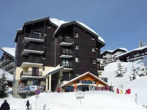 ein großes Gebäude auf einem schneebedeckten Berg in der Unterkunft Charmant appart au 2e étage, 5 pers, balcon, WiFi, casier à skis, Les Saisies - FR-1-293-287 in Hauteluce