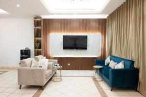 a living room with two chairs and a blue couch at دره العروس فيلا الروز للعائلات in Durat Alarous