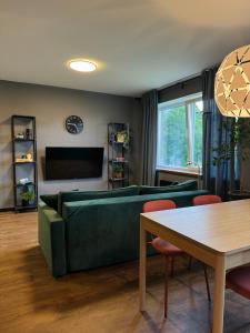 un soggiorno con un divano verde e un tavolo di Little green studio in Maardu a Maardu