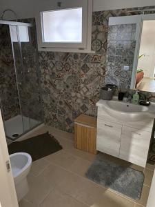 a bathroom with a sink and a toilet and a mirror at Salenzia apartment in San Cesario di Lecce +10 photos