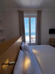 a bedroom with a bed with a view of the ocean at Hotel Dania in Sorrento