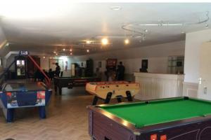 a room with several pool tables in a room at Mobilhome camping 4 étoiles proche plage in Quend