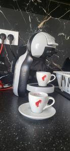 a coffee maker with three cups on a counter at Apartmani Banja Vrujci Lux in Gornja Toplica