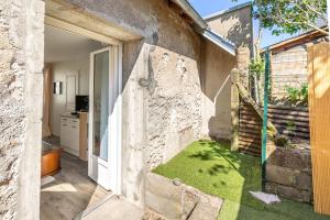 an open door to a house with a grass yard at Maisonnette cosy proche des 2 Gares et du centre ville Orléans in Orléans