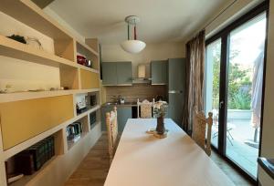 a kitchen with a dining table and a large window at Casa Vacanze Al Cielo 2 in Sarnano