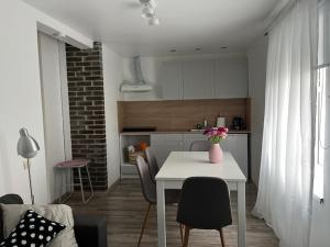 a kitchen with a table and chairs in a room at Ostsee Apartments in Ventspils +4 photos