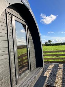 a door in a building with a view of a field at Cow Pasture Pod in Whitby +10 photos
