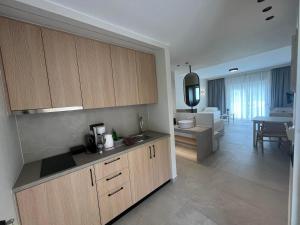 a kitchen with wooden cabinets and a living room at Mediterranean Sea Top Floor in Palaiochora