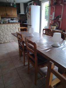 a kitchen with a wooden table and chairs at Bugatti 4 chambres- 4 lits doubles in Teloché