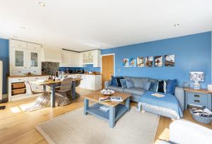 Una sala de estar con un sofá y una cocina. en 8 Fernhill, en Carbis Bay