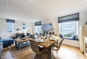 Un comedor y una sala de estar con mesa y sillas. en 8 Fernhill, en Carbis Bay