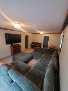 a living room with a large couch and a flat screen tv at ReTreat yourself in Port Franks in Lambton Shores