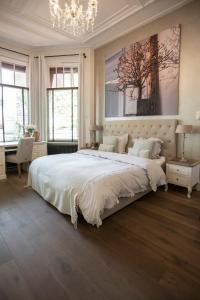 a bedroom with a large bed and a chandelier at Zenzez Hotel & Lounge in Apeldoorn