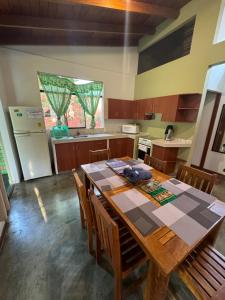 eine Küche mit einem Tisch mit Stühlen und einem Kühlschrank in der Unterkunft Bungalow de 01 piso en casa de campo El Valle Inn in Cieneguilla + 3 Fotos