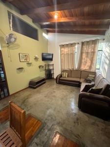 ein Wohnzimmer mit zwei Sofas und einem Flachbildfernseher in der Unterkunft Bungalow de 01 piso en casa de campo El Valle Inn in Cieneguilla