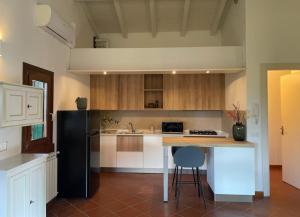 a kitchen with a black refrigerator and a counter at Garda Golf Studio in Soiano del Lago