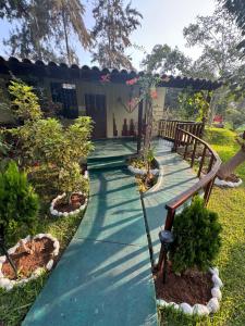 einen Gehweg in einem Garten mit einem Haus in der Unterkunft Bungalow de 01 piso en casa de campo El Valle Inn in Cieneguilla