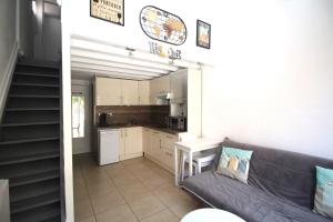 ein Wohnzimmer mit Couch und Küche in der Unterkunft CORAUX - Maisonnette 4 pers avec piscine et parking in Canet-en-Roussillon