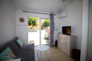 ein Wohnzimmer mit Sofa und Tisch in der Unterkunft CORAUX - Maisonnette 4 pers avec piscine et parking in Canet-en-Roussillon