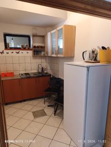 a kitchen with a white refrigerator and a table at Apartments Salute in Mostar +18 photos