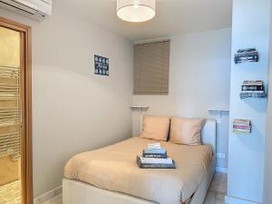a small bedroom with a bed with books on it at La plus belle vue sur mer à Juan les Pins in Antibes
