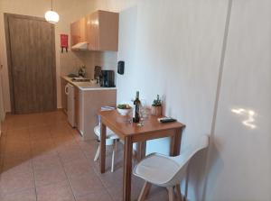 a small kitchen with a wooden table and white chairs at Nikolaos Studios Skala in Skala