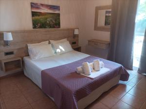 a bedroom with a bed with two towels on it at Nikolaos Studios Skala in Skala Kefalonias