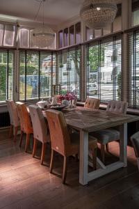een eetkamer met een grote houten tafel en stoelen bij Zenzez Hotel & Lounge in Apeldoorn