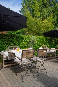 two chairs and a table with an umbrella at Zenzez Hotel & Lounge in Apeldoorn