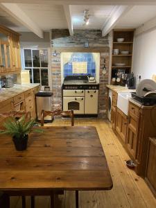 a kitchen with a wooden table and a stove at Jacobs Cottage in Port Isaac