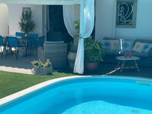 een zwembad in een tuin met een patio bij Villa Adel in San Teodoro +62 foto's