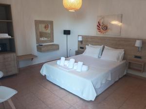 a bedroom with a white bed with candles on it at Nikolaos Studios Skala in Skala