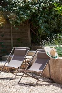 two chairs and a hat sitting next to a wall at Les Maisons Du Sud in Saint-Tropez