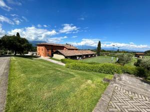 a large yard with a tennis court in front of a building at Garda Golf Studio in Soiano del Lago