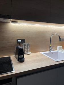 a kitchen counter top with a sink and a kitchenilit at Andromachi's House in Pefkochori +25 photos