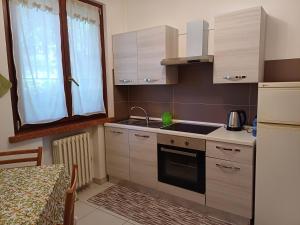 a kitchen with white cabinets and a sink and a window at Appartamento b&b Villa Aroma in Mottella