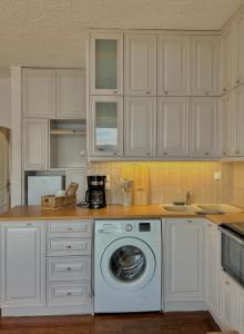 a white kitchen with a washing machine in it at Iris Sunset View Home in Samos +24 photos
