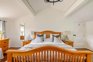 a bedroom with a large bed with wooden furniture at Rhos y Bel Cottage Angelsey in Llangadwaladr