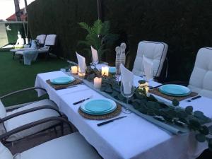 a white table with blue plates and candles on it at Apartamento con Piscina Ribadumia in Ribadumia