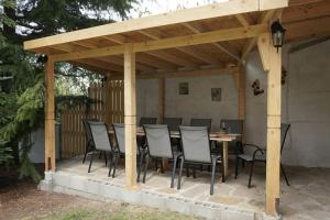 a wooden pavilion with a table and chairs on a patio at Forest house in Varna City