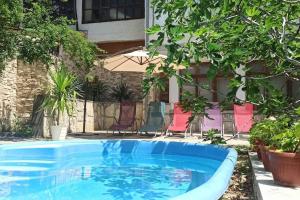 a swimming pool in a yard with chairs and an umbrella at Forest house in Varna City