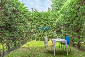 two chairs and a table in a yard with trees at Ville Martellozzo in Lido di Jesolo