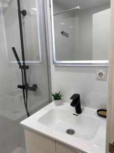a white bathroom with a sink and a shower at Estudio con Piscina y Parking, Playa a 4 Min a Pie, Tren a 2 Min in Fuengirola