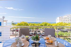 a table with food on a balcony with a view of a marina at MILLENIUM 1 2-1 in Roses