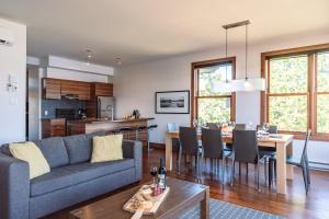 a living room with a couch and a table at Lakefront, Mountain View - 3 Bedrooms Resort Suite in Lac-Superieur +32 photos