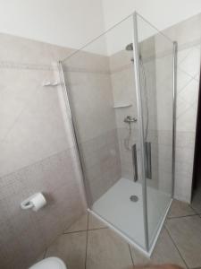 a shower with a glass door in a bathroom at villa Beatrice in Serranova